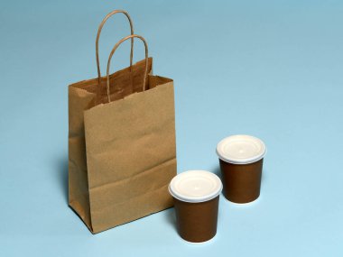 Masanın üzerinde kahve ve yiyecek olan kağıt paket.