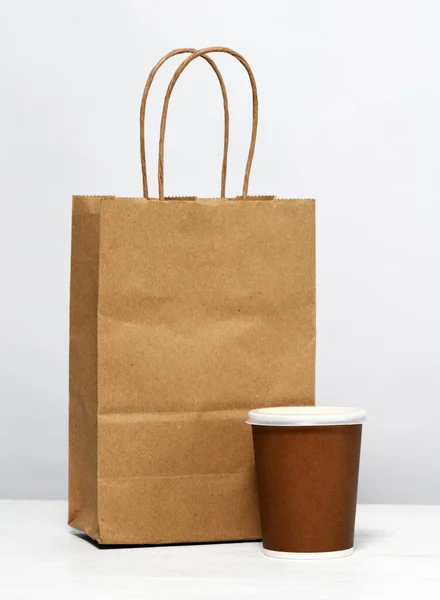 Paper package with food and coffee on the table