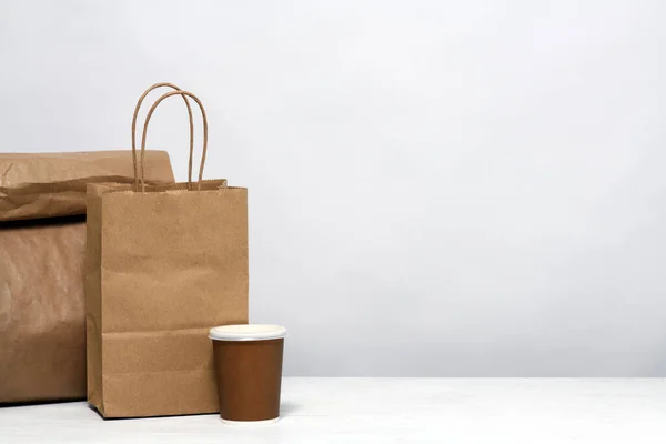 Paper package with food and coffee on the table