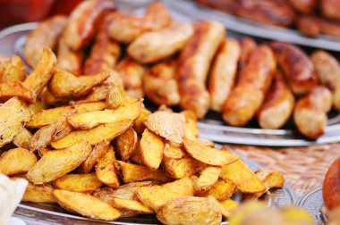 Fırında baharatlı patates plaka, closeup üzerinde. Kızartma patates ve sosis içinde belgili tanımlık geçmiş