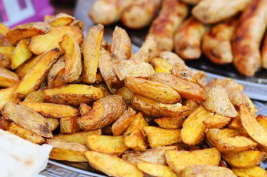 Fırında baharatlı patates plaka, closeup üzerinde. Kızartma patates ve sosis içinde belgili tanımlık geçmiş
