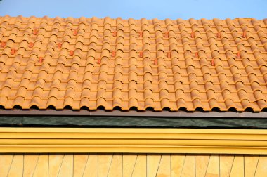 Mavi gökyüzü kiremitli çatıya çatı ev. ayrıntı fayans ve köşe montaj çatıda, yatay. 