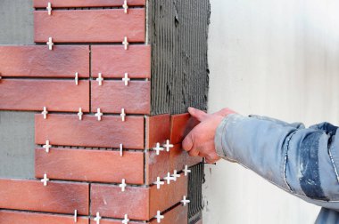 Bina cephe Dekoratif Karo yükleme kiremitçi inşaat işçisi. Yalıtılmış ve sıvalı cephe. Bitmemiş İnşaat.