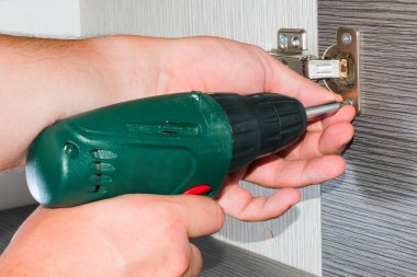 marangoz, Mobilya Kapı Menteşesi, bir vida vidalama Akülü tornavida kullanarak dolap, bağlar.