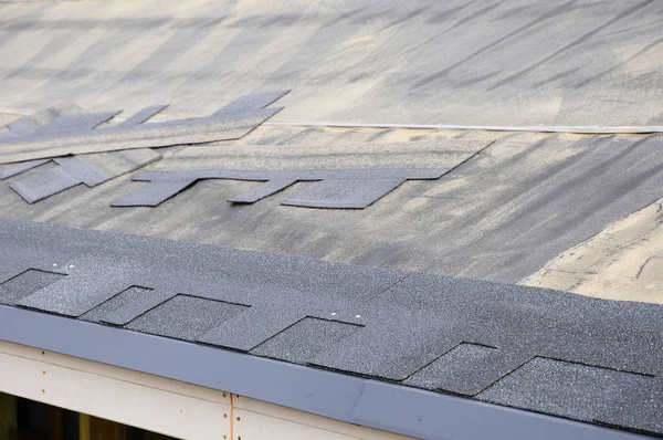 瀝青タイル屋根。帯状疱疹をインストールします。アスファルト屋根の鉄片をインストールします。. — ストック写真