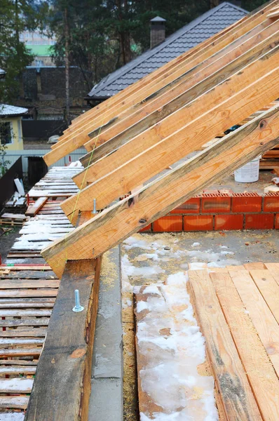 木制的屋面工程施工。房屋建筑。安装的木梁施工在房子的屋顶桁架体系。屋顶下施工。未完成的屋面施工 — 图库照片