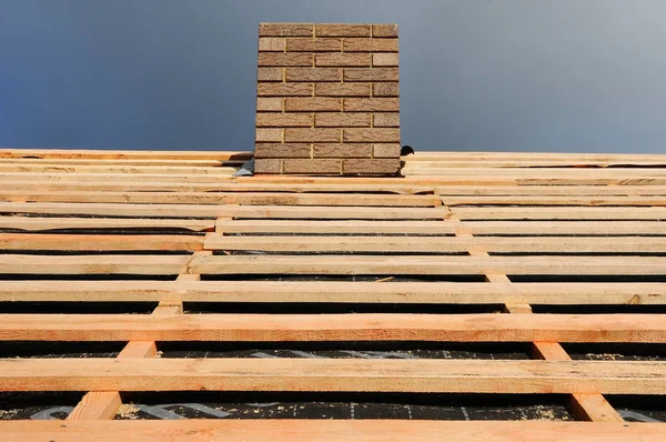 Dachkonstruktion aus Holz. Montage von Holzbalken an der Dachkonstruktion. Dach im Bau. Installation der Dampfsperre auf dem Dach. Schornsteinsystem — Stockfoto