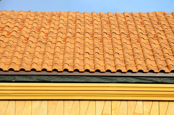Mavi gökyüzü kiremitli çatıya çatı ev. ayrıntı fayans ve köşe montaj çatıda, yatay. 