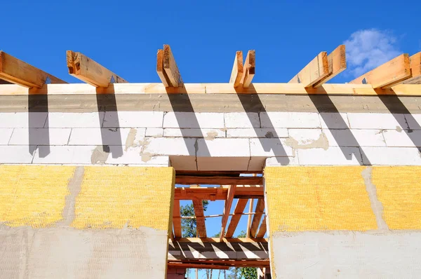 Mavi gökyüzüne karşı çerçevelenen yeni konut inşaatı. Çatı inşaatı. 