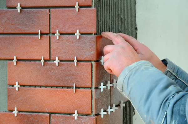 Bina cephe Dekoratif Karo yükleme kiremitçi inşaat işçisi. Yalıtılmış ve sıvalı cephe. Bitmemiş İnşaat.