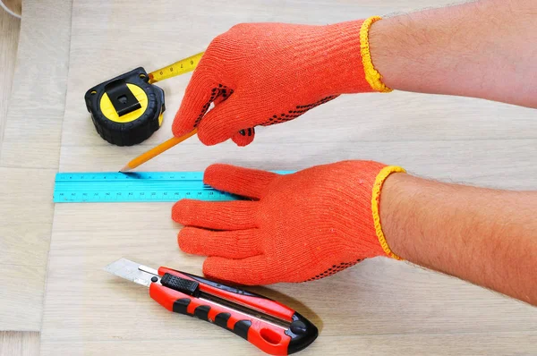 İşçi, muşambanın üzerinde ölçülmüş ve işaretlenmiş. Muşamba kesen bir işçi. bant Ölçümü