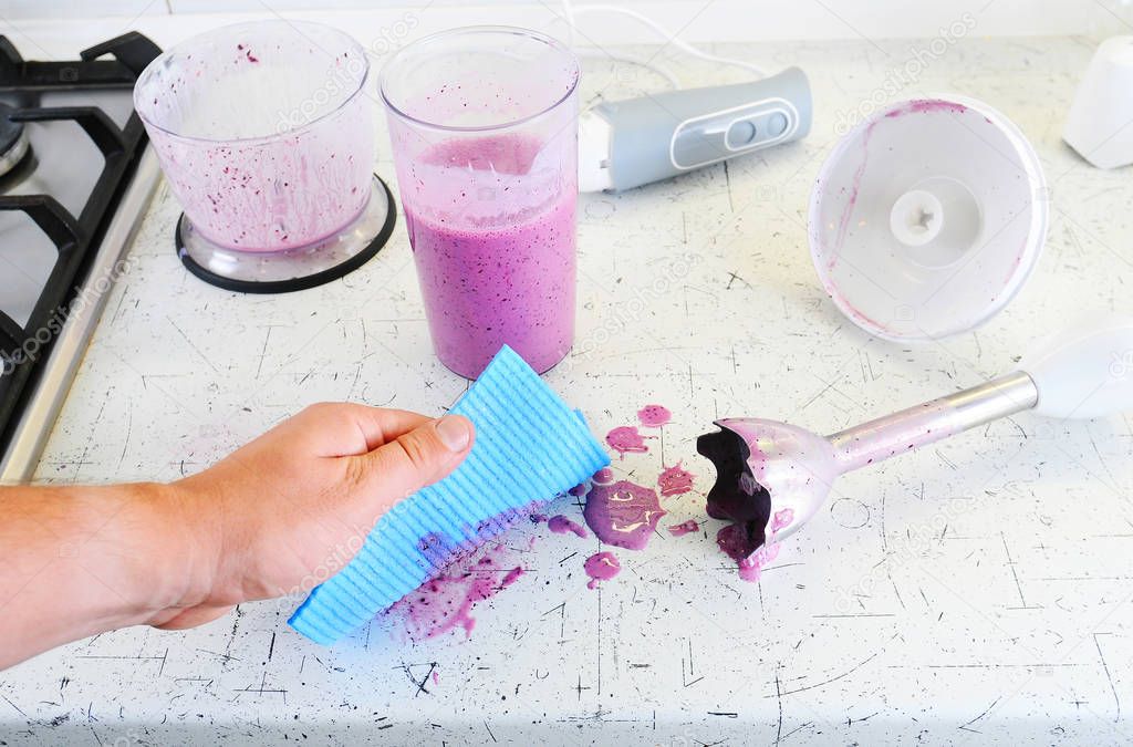 Man's hand wiping a work surface. cleaning after cooking