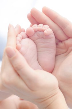 Bizim mucize çocuklar. Bebeğin ayakları mom'ın elinde. Çocuk güvenliği. Bebek Bakımı