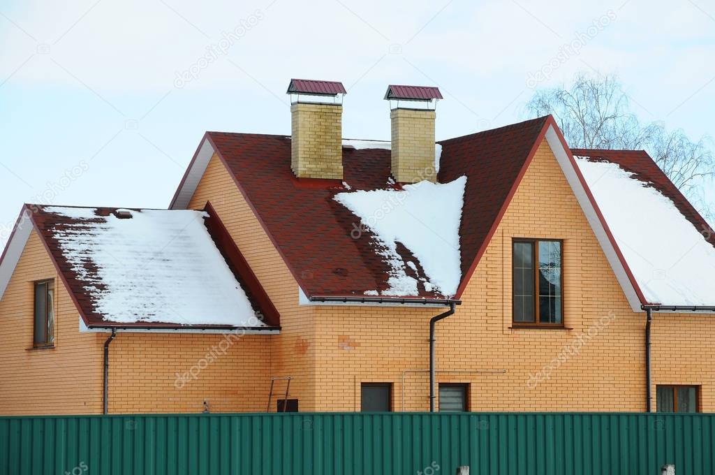 Bitumen asphalt shingles roof. Two chimneys on the roof of the house individual heating. Modern new home 