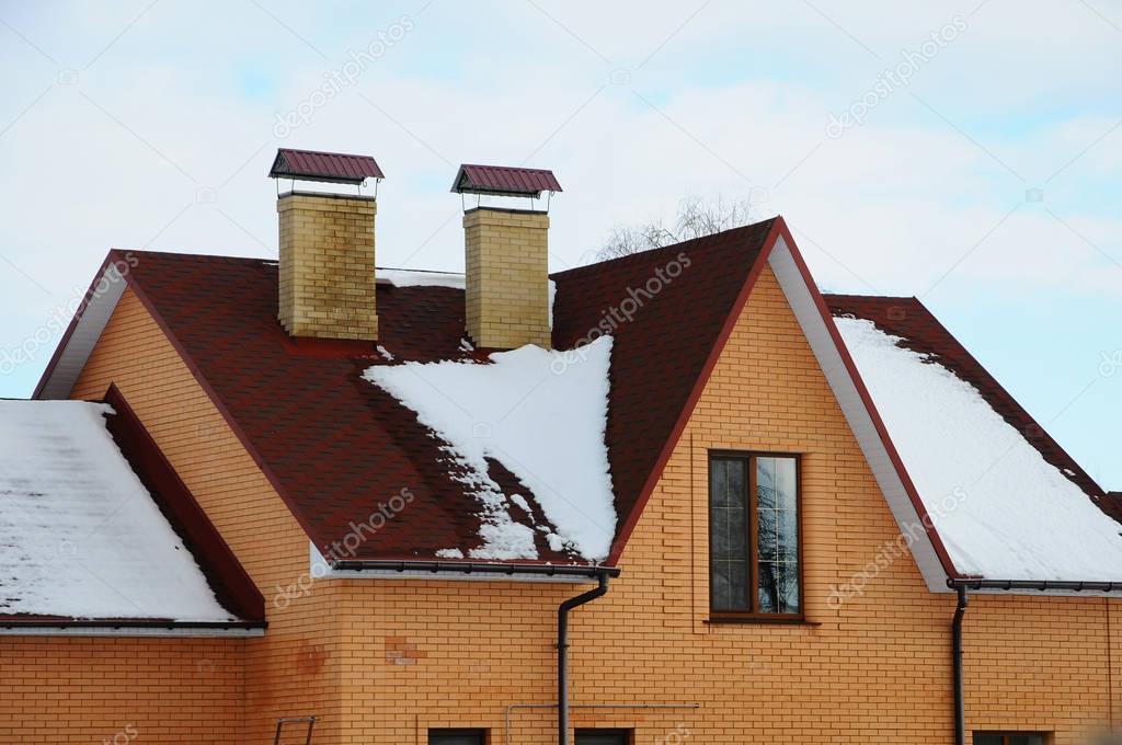 Bitumen asphalt shingles roof. Two chimneys on the roof of the house individual heating. 