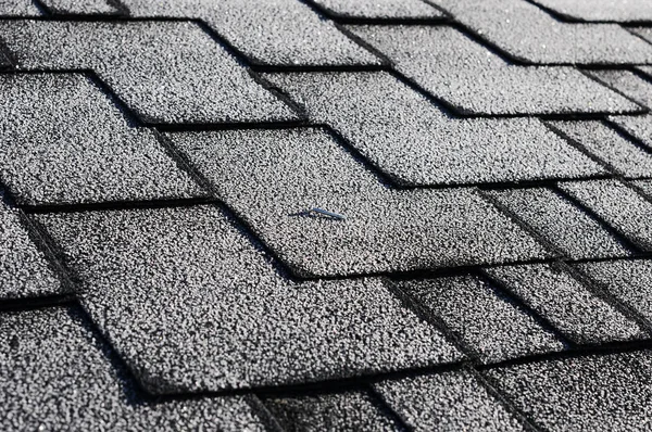 Nära håll syn på asfalt takshingel täckt med frost — Stockfoto