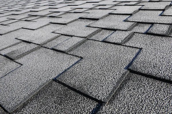 Stäng upp syn på asfalt tak bältros bakgrund. Tak bältros - takläggning. Tak bältros täckt med frost — Stockfoto