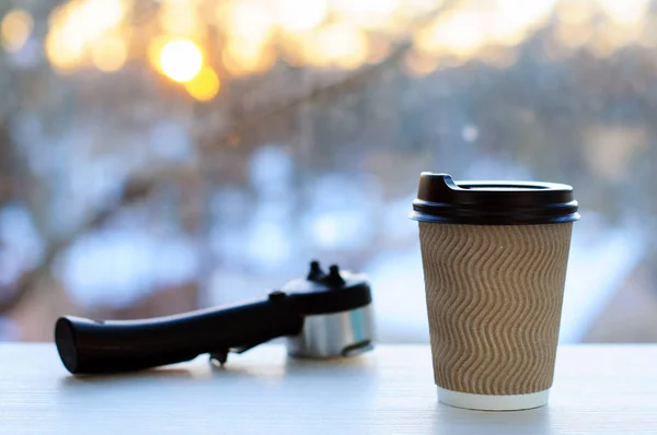 Paper Cup with coffee on background of dawn. Cup of coffee.