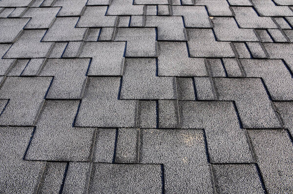 Close up view on Asphalt Roofing Shingles Background. Roof Shingles - Roofing. Roof shingles covered with frost