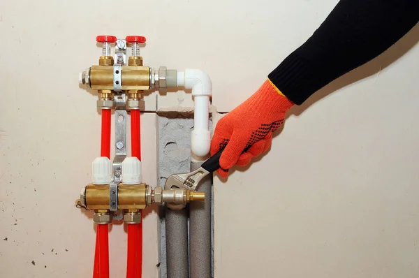 Instalación individual de calefacción doméstica. Un fontanero conecta el tubo a la calefacción del colector . — Foto de Stock