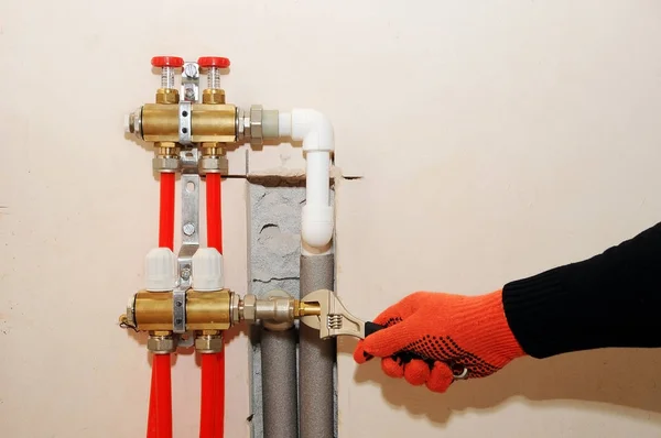 Instalación individual de calefacción doméstica. Un fontanero conecta el tubo a la calefacción del colector . — Foto de Stock