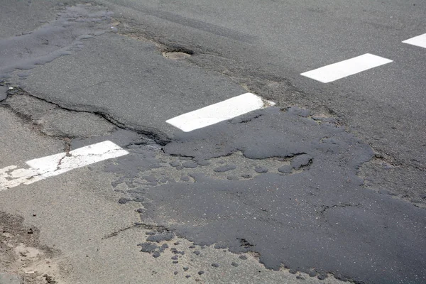 Má qualidade do trabalho de reparação rodoviária. Estrada de asfalto danificada, estrada ruim . — Fotografia de Stock