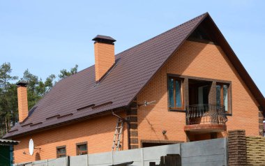 Metal çatı. Closeup yeni yağmur oluk sistemi ve çatı koruma kar Kurulu (kar guard) ev yapımı üzerinde. Uydu anteni. Sistem bacalar