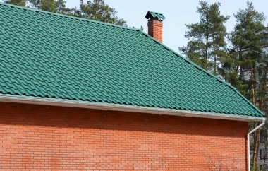 Metal çatı. Bir mansard ve metal çatı çatı penceresi windows ile bir tuğla ev.