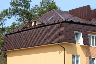 Çatı metal çatı üstünde pencere eşiği. Metal çatı mansard windows ve yağmur oluk ile yapılmış bir çatı ile bir ev.