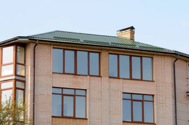 Kiev, Ukrayna - 15 Nisan 2017: Metal çatı. Büyük modern ev büyük pencereler ve balkon. Evin çatı üstüne yağmur oluk. metal çatı. Baca boru.