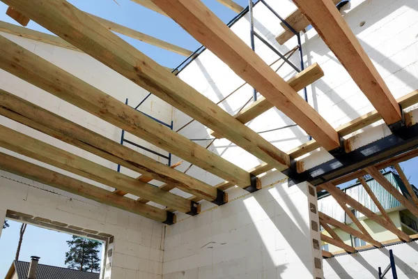 The wooden structure of the building. Wooden frame building. Wooden roof construction. photo for home. house building. Installation of wooden beams at construction the roof truss system of the house. — Stock Photo, Image