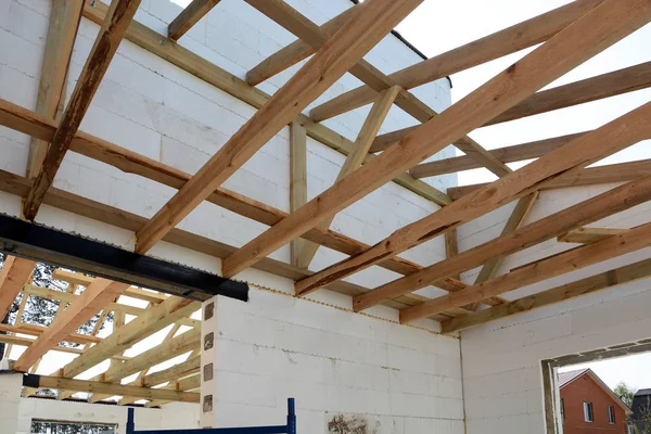 Die Holzkonstruktion des Gebäudes. Holzrahmenbau. Dachkonstruktion aus Holz. Hausbau. Montage von Holzbalken beim Bau des Dachstuhlsystems des Hauses. — Stockfoto