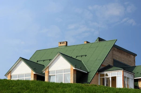 KIEV, UKRAINE - APRIL 15, 2017: Metal roofing. Rain Gutter Pipeline with Downspout Pipe and Attic Mansard Window. Roofing Construction, Roofing Repair. The house with plastic windows and a green roof. — Stock Photo, Image