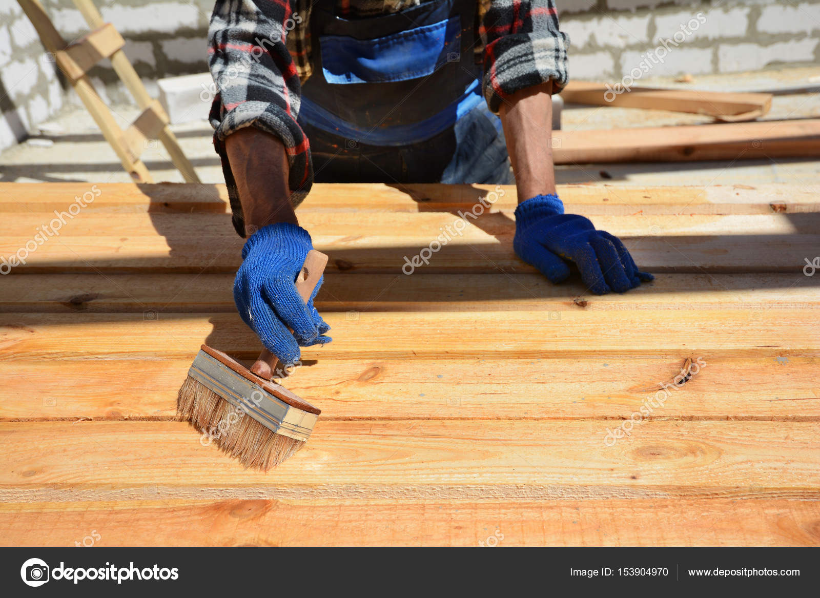 Bauarbeiter arbeitet mit Holzbalken. Die Arbeitskraft Bürsten die ... Bauarbeiter arbeitet mit Holzbalken. Die Arbeitskraft Bürsten die ...