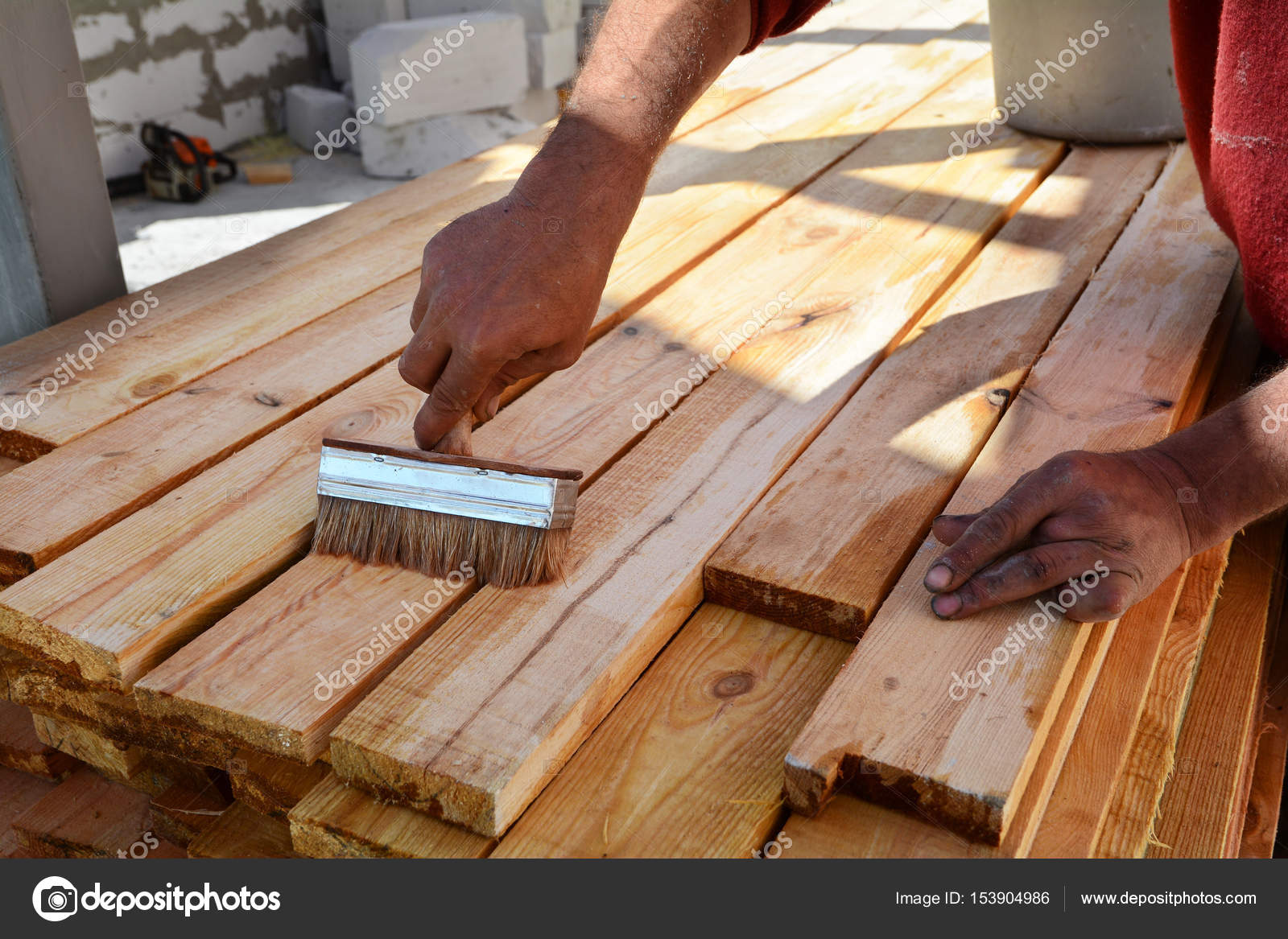 Bauarbeiter arbeitet mit Holzbalken. Die Arbeitskraft Bürsten die ... Bauarbeiter arbeitet mit Holzbalken. Die Arbeitskraft Bürsten die ...