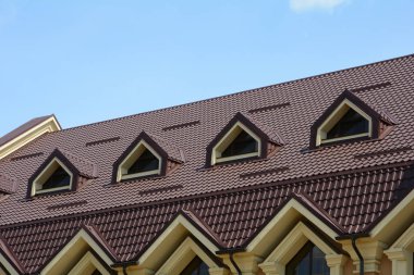 Çatı metal çatı üstünde pencere eşiği. Metal çatı mansard windows ve yağmur oluk ile yapılmış bir çatı olan bir ev. Metal çatı kaplama.