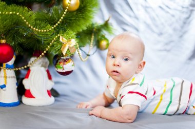 Noel ağacı yakınındaki mavi gözlü bebek. Yeni yıl. Büyük mavi gözler. Şirin mavi gözlü bebek