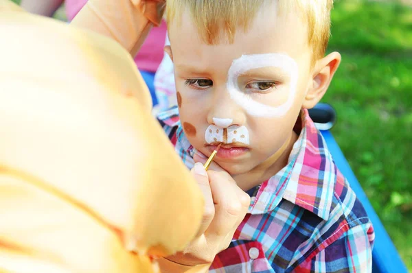 Adorable niñito haciéndose pintar la cara. Niños pintados — Foto de Stock