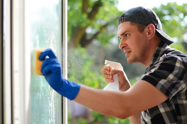 Joven limpiando ventanas. Lavadora de ventanas . — Foto de Stock