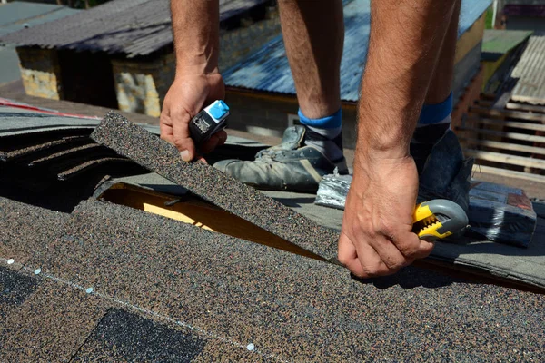 从瓦屋面的修复。屋顶的切割油毡或沥青在防水工程。屋顶瓦片-屋面。沥青瓦屋面. — 图库照片