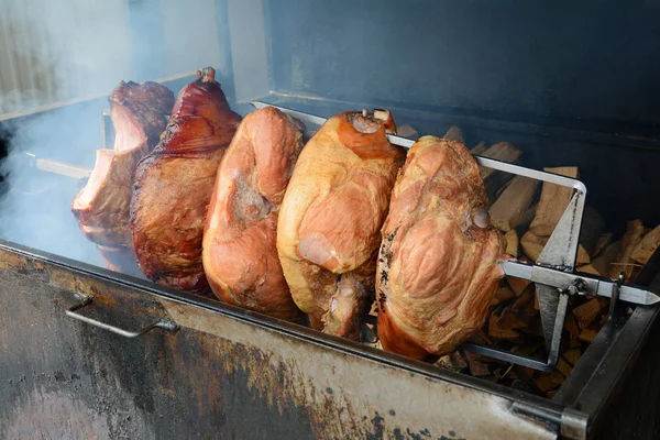 Pork ham meat is roasted on the open fire. Street Czech food in the grill. — Stock Photo, Image