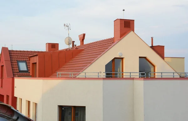 Новая крыша из красных черепиц с окнами Skylights и дождевой канавой. Новый кирпичный дом с дымоходом и вентиляцией — стоковое фото