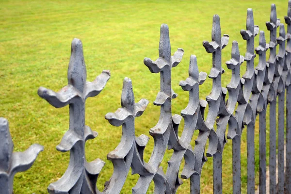 Bela cerca forjada. Imagem de uma cerca de ferro fundido decorativo. cerca de metal perto. Cerca forjada de metal. cerca bonita com forjamento artístico — Fotografia de Stock