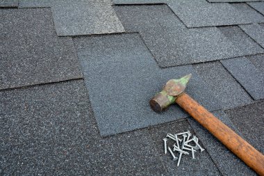 Çatı Zona - çatı kaplama. Zona bir çatı üzerinde çekiç ve çivi ile asfalt. Asfalt çatı Zona arka plan üzerinde görünümü kadar kapatın. 