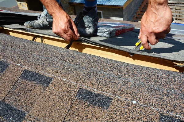 La reparación del techado del herpes zóster. Roofer corte de fieltro para techos o betún durante las obras de impermeabilización. Tejas - Techos. techo de azulejo de betún . — Foto de Stock