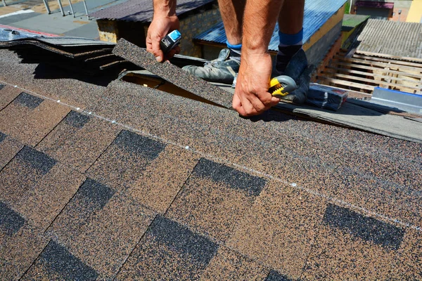 从瓦屋面的修复。屋顶的切割油毡或沥青在防水工程。屋顶瓦片-屋面。沥青瓦屋面. — 图库照片