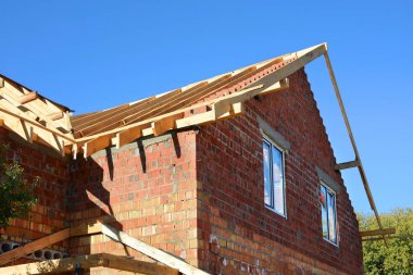 Ev yapım aşamasında. Ahşap çatı konstrüksiyonu. Bitmemiş ev inşa. Yükleme ahşap inşaat çatı makas sistemi evin kirişler..