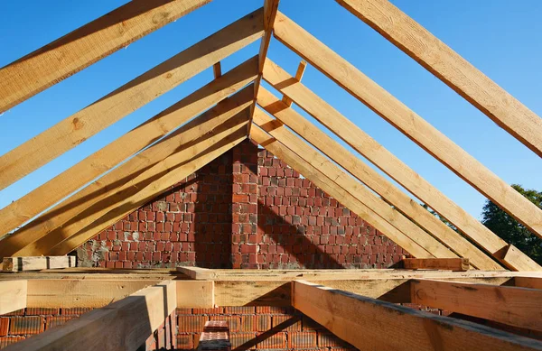 Dachkonstruktion aus Holz. unvollendeter Hausbau. Montage von Holzbalken beim Bau des Dachstuhlsystems des Hauses. — Stockfoto