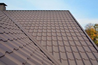 Metal çatı inşaat mavi gökyüzü karşı. Çatı kaplama malzemeleri. Metal ev çatı. Closeup House İnşaat yapı malzemeleri. Çatı inşaat. Eş eksenli boru sistemi ev koaksiyel baca boru Isıtma.