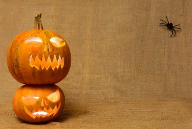 Korkunç parlayan kabaklar yüzler. Bir çuval bezi arka plan üzerinde izole korkunç Halloween pumpkins.